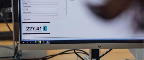 Monitor im Deutsche-Post-Büro wird aus Sicht einer Mitarbeiterin gezeigt