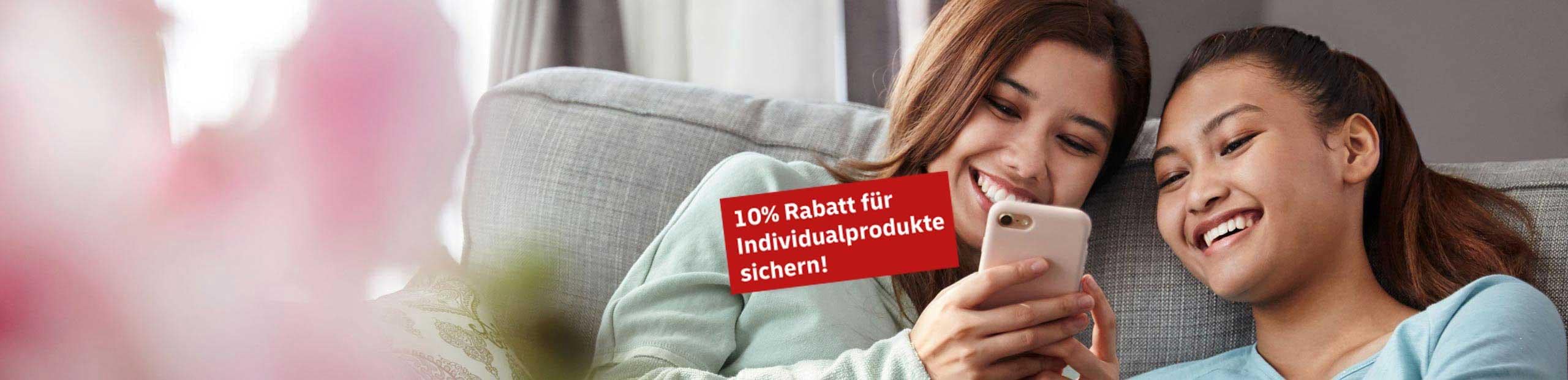 2 Frauen liegen auf der Couch und schauen fröhlich zusammen auf ein Handy. Es gibt einen roten Störer mit dem Inhalt: 