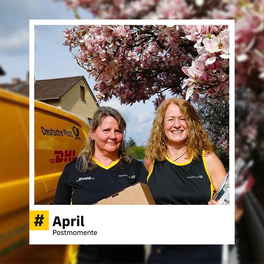 Zwei fröhliche Postmitarbeiterinnen stehen unter blühenden Kirschbäumen neben einem gelben DHL-Fahrzeug. Eine hält ein Paket in der Hand. Hashtag: „#April – Postmomente“.