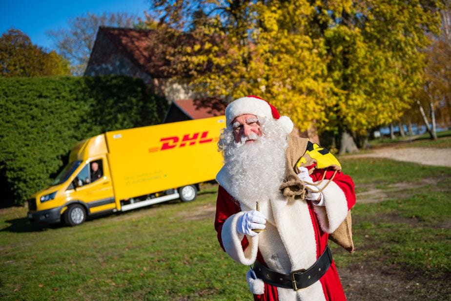 Weihnachtsmann mit DHL Transporter