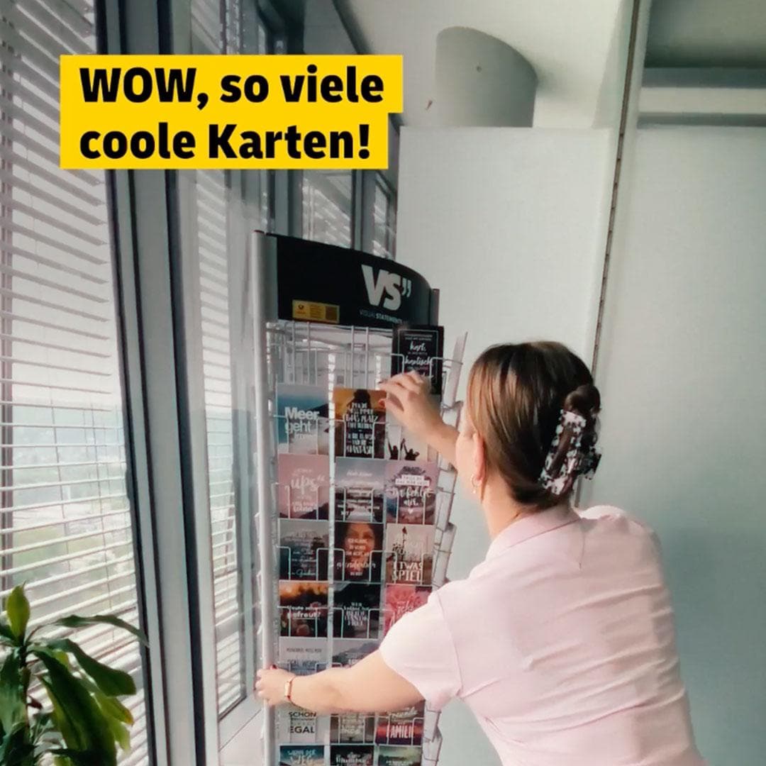 Frau betrachtet begeistert einen vollen Sammelkartenautomaten in einem Innenraum. Text: „WOW, so viele coole Karten!“